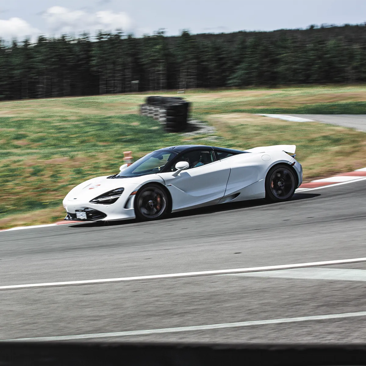 White Lotus Emira taking high speed corner on the Vancouver Island Motorsport Circuit.