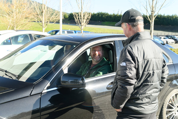 Drivers listening to drive bebrief from instructor while sitting in car at the Vancouver Island Motorsport Circuit